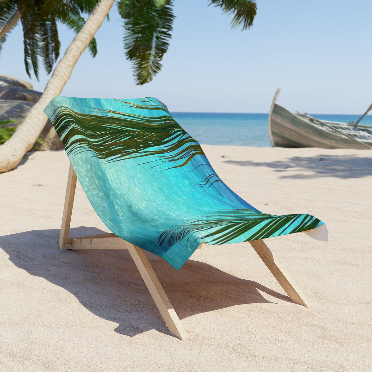 Palm Frond Lagoon beach towel draped over a wooden beach chair on the sand (chair not included)