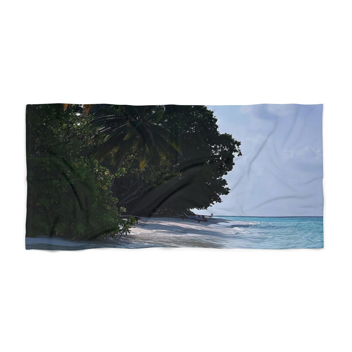 Shady Shoreline beach towel laid flat: dark green branches over a white-sand beach with turquoise water and pale sky